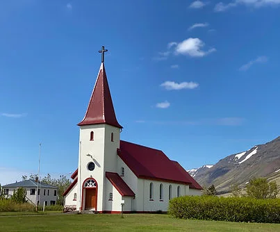 Icelandic church with red roof and mountains